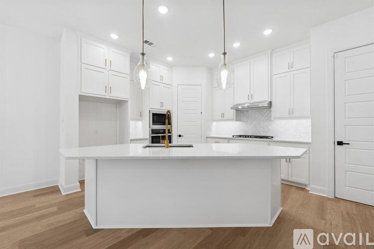 A modern kitchen with white cabinets and a central island.