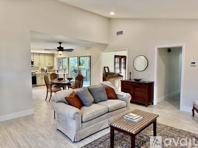 A living room with a couch, a coffee table, and a ceiling fan.