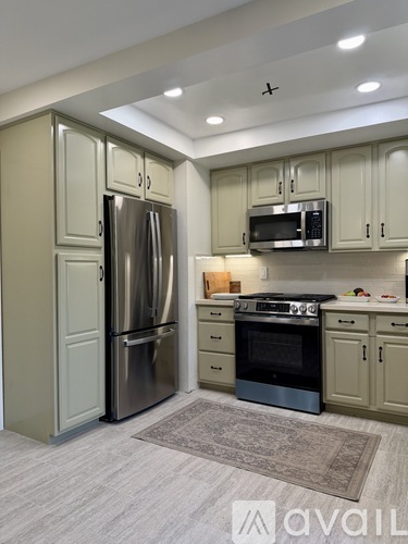 A kitchen with a refrigerator, oven, and microwave.