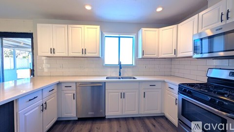 A kitchen with white cabinets and a stainless steel dishwasher.