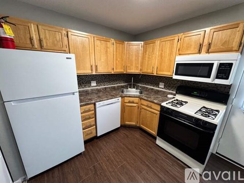 A kitchen with wooden cabinets and white appliances.
