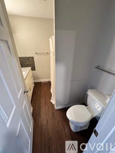 A small bathroom with a toilet and a shower stall.