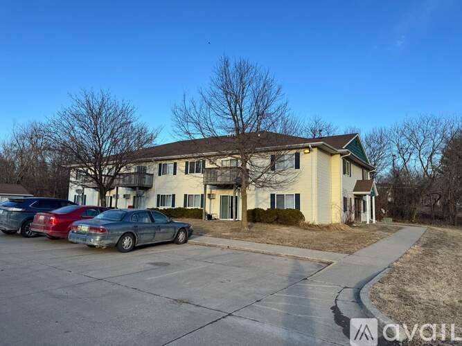 A house with a driveway and cars parked in front.