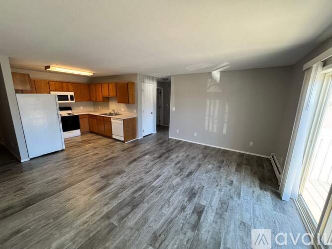 A spacious kitchen with wooden cabinets and a white refrigerator.