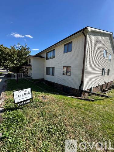 A two-story house with a sign that says "HARD+ FOR RENT".