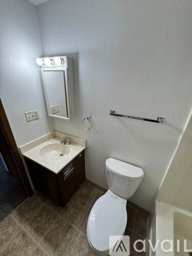 A small bathroom with a toilet, sink, and mirror.