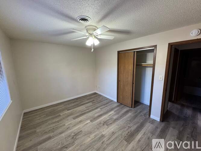 A room with a ceiling fan and a door.