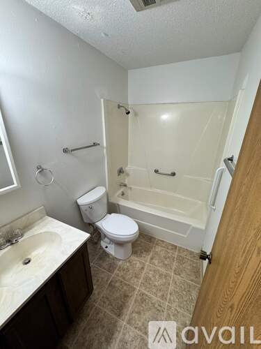 A bathroom with a toilet, sink, and bathtub.
