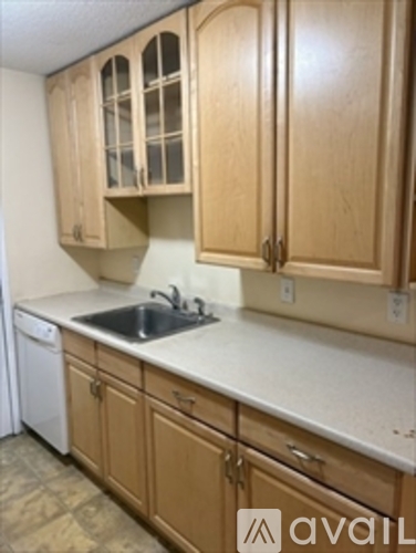 A kitchen with wooden cabinets and a white countertop.