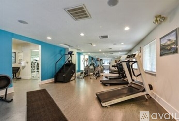 A gym with treadmills, elliptical machines, and other exercise equipment.