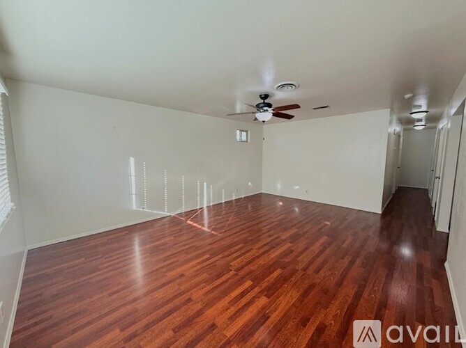 A room with wooden flooring and a ceiling fan.