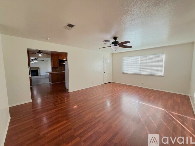 A room with wooden floors and a ceiling fan.