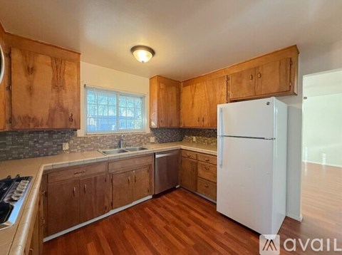 A kitchen with wooden cabinets and a white refrigerator.