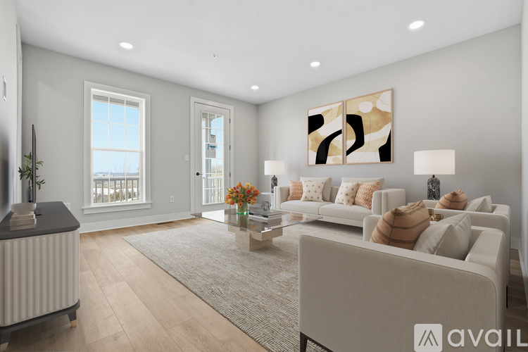 A modern living room with a large sofa, a coffee table, and a painting on the wall.