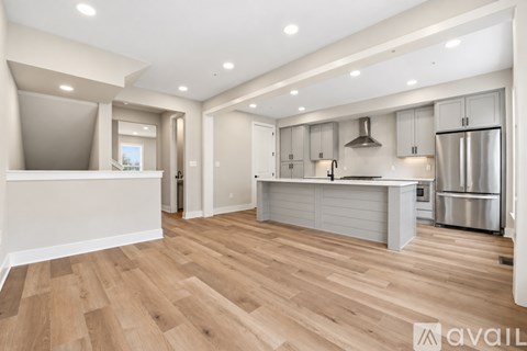 A modern kitchen with white cabinets and stainless steel appliances.