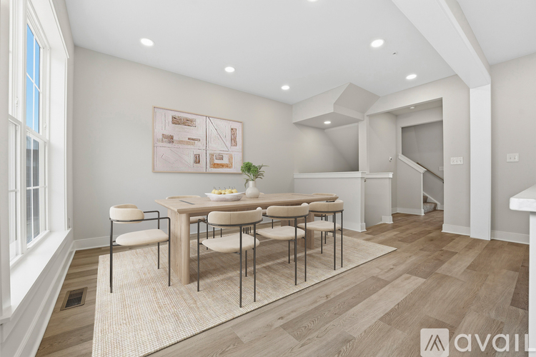 A dining room with a table set for four and a potted plant on the table.