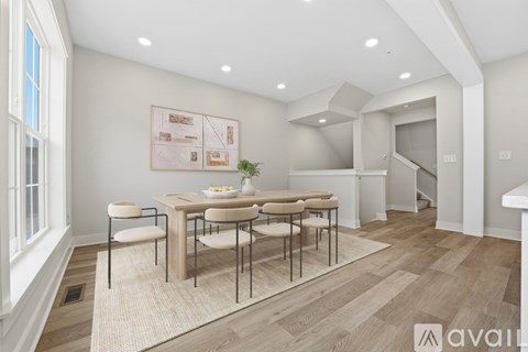 A dining room with a table set for four and a potted plant on the table.