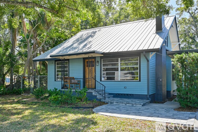 A small house with a metal roof and a porch.