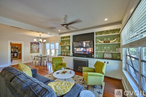 A living room with a grey couch and a green chair.
