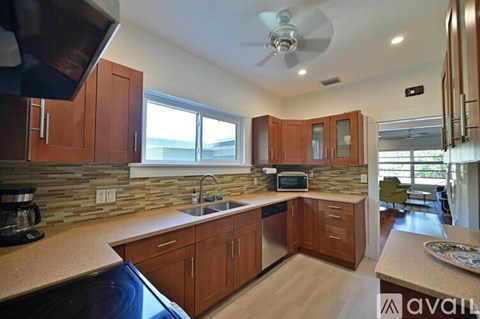 A kitchen with wooden cabinets and a stone backsplash.