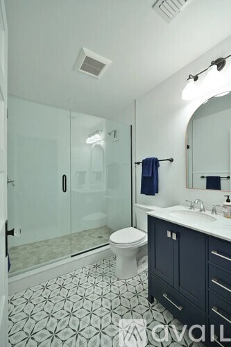 A bathroom with a toilet, sink, and mirror.