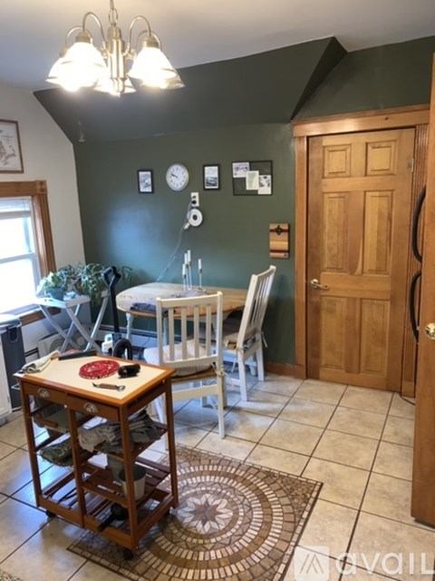 A dining room with a table and chairs.