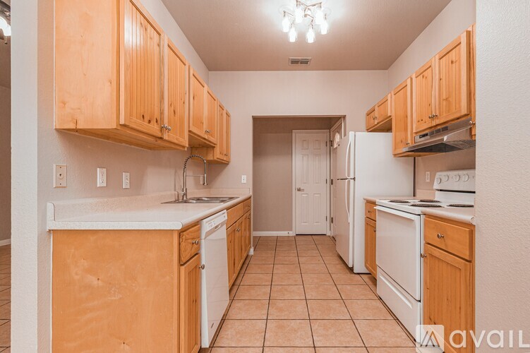 A kitchen with wooden cabinets and white appliances.