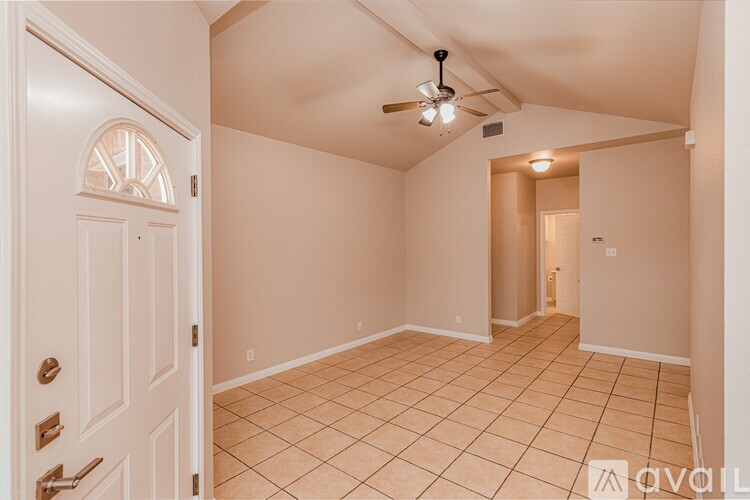 A room with a ceiling fan and a door with a window.