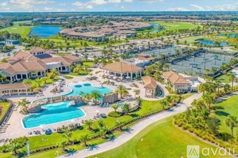 A bird's eye view of a resort with a swimming pool and palm trees.