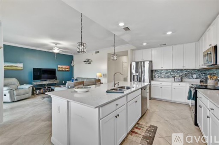 A modern kitchen with white cabinets and a central island.