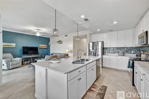 A modern kitchen with white cabinets and a central island.