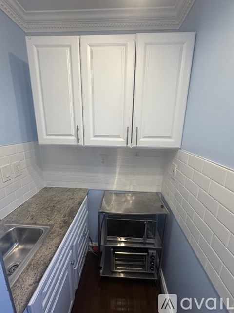 A kitchen with white cabinets and a sink.