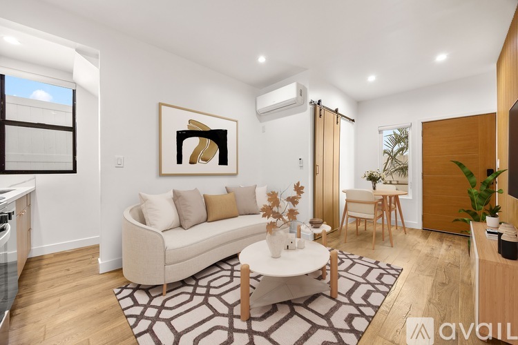 A living room with a beige couch, a coffee table, and a painting on the wall.