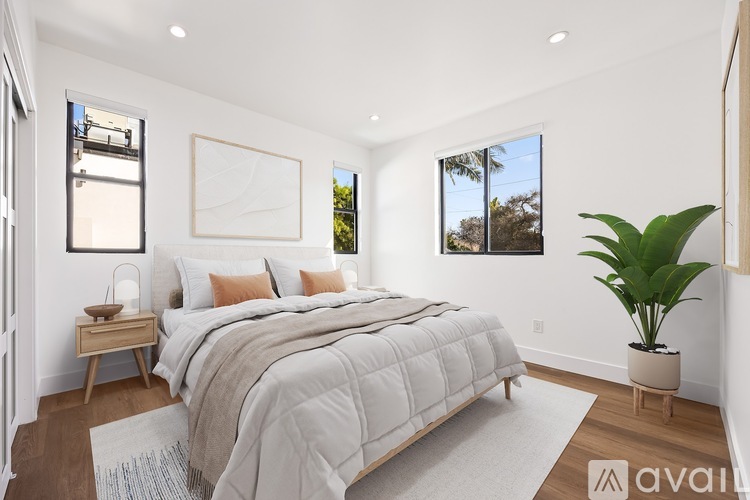 A bedroom with a large bed and a plant.