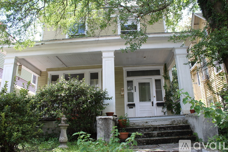 A house with a white door and a porch with a stone pillar.