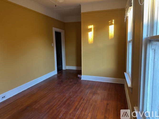 A room with wooden floors and yellow walls.