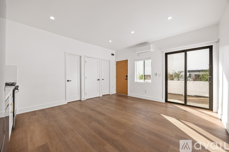 A spacious room with wooden floors and white walls.