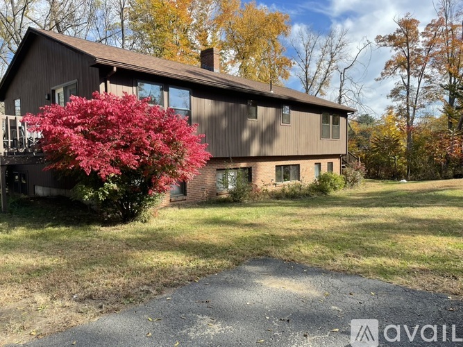 A house with a red bush in front of it.