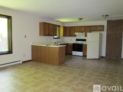 A kitchen with a white refrigerator and wooden cabinets.