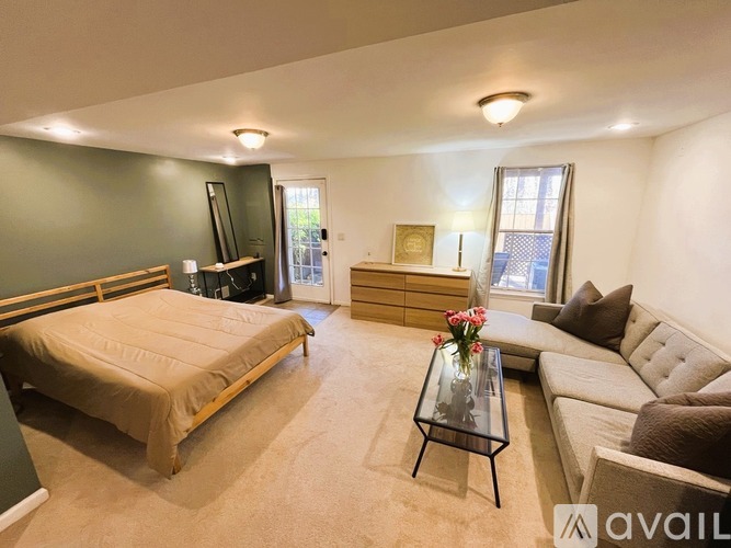 A bedroom with a bed, couch, and television.