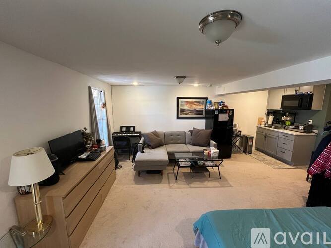 A living room with a couch, a chair, a television, and a lamp.