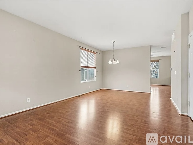 A spacious room with wooden beams on the ceiling and a concrete floor.