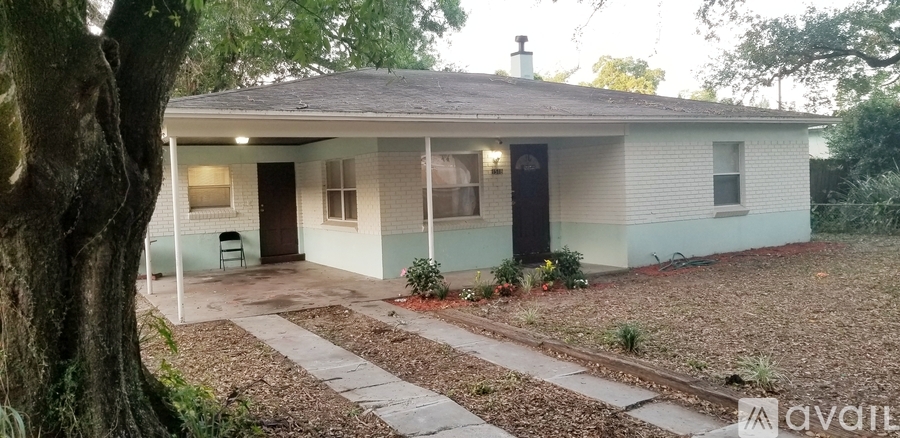 A house with a front porch and a tree in front of it.