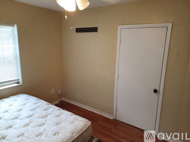 A bedroom with a white bed and a white door.