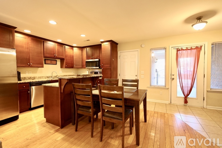A kitchen with wooden cabinets and a dining table with chairs.