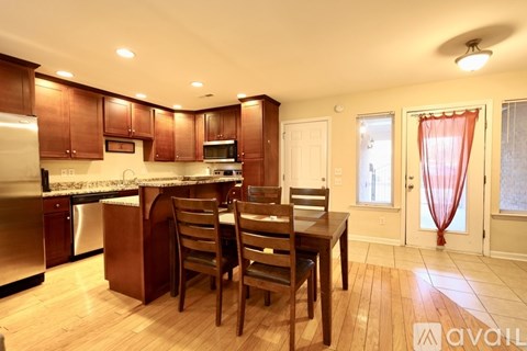 A kitchen with wooden cabinets and a dining table with chairs.