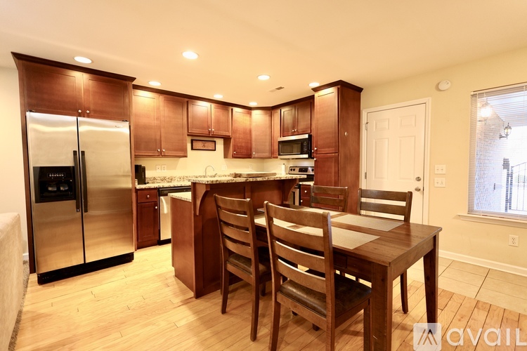 A kitchen with wooden chairs and a table.