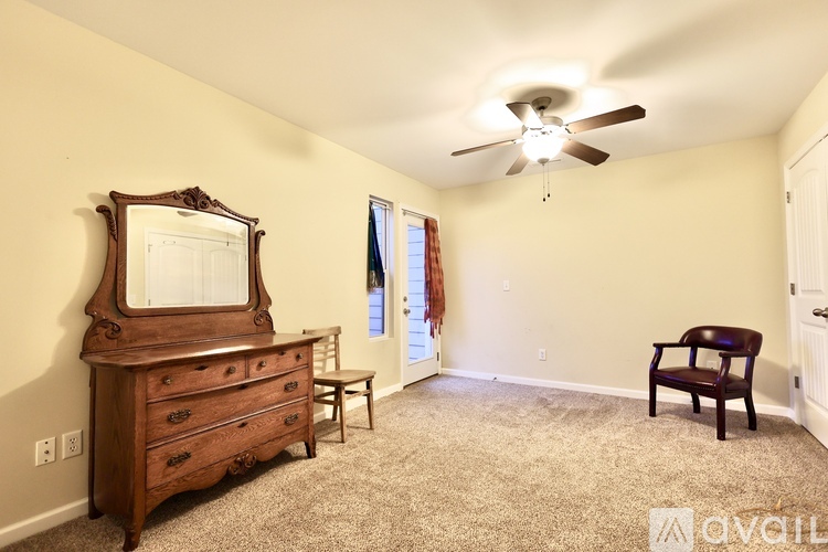 A bedroom with a dresser and a chair.