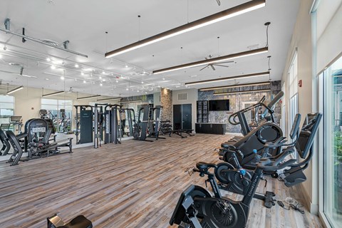 A gym with a variety of equipment including treadmills, weights, and exercise machines.