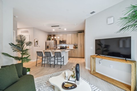 A modern living room with a green couch and a wooden entertainment center.